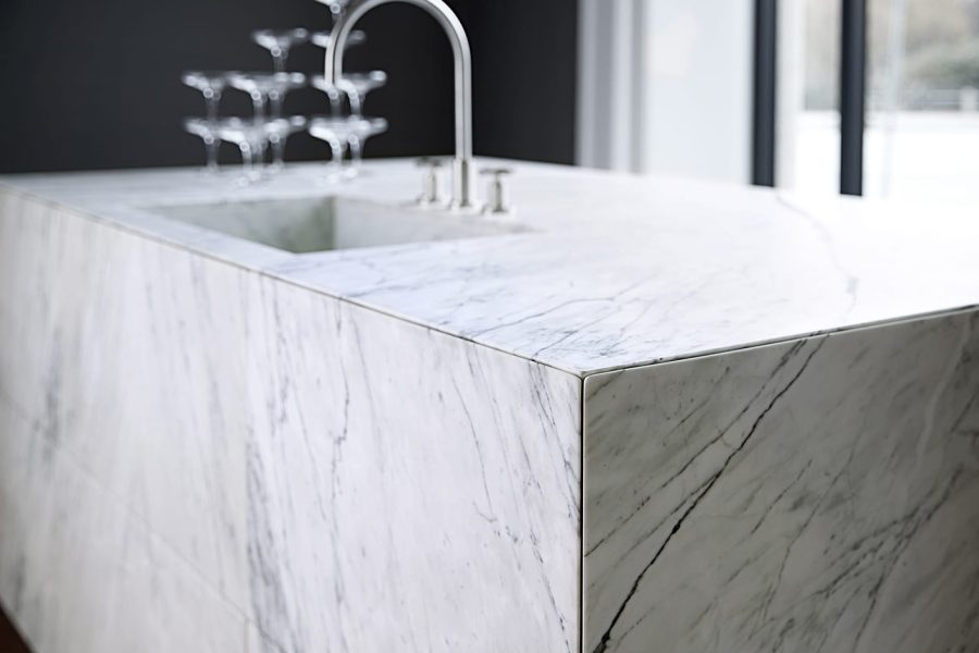 Den spillevende Staturario Venato marmor med gennemgående åretegninger forvandler køkkenelementet til en skulptur.