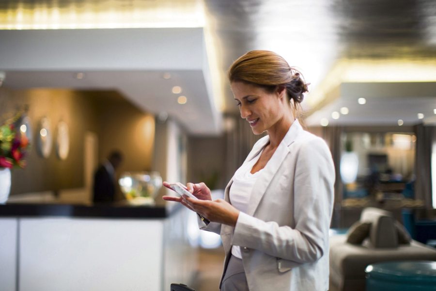 Businesswoman using phone in hotel